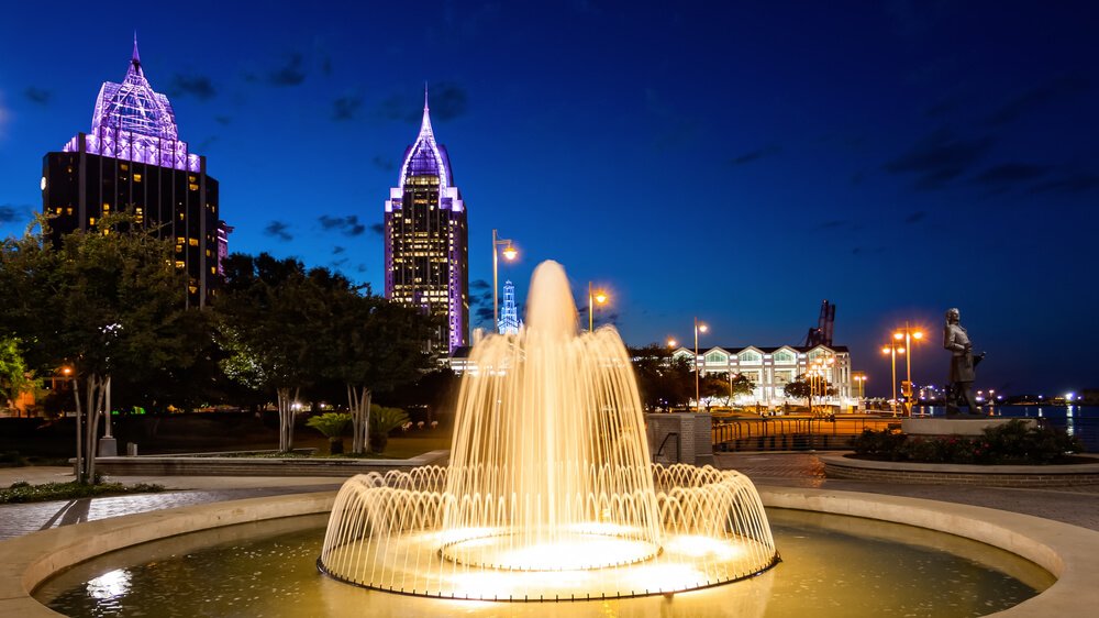 fountain in mobile alabama lit up at night in festive color