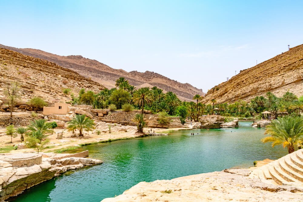 Wadi Bani Khalid in Oman, with beautiful blue water in this desert oasis and palm trees
