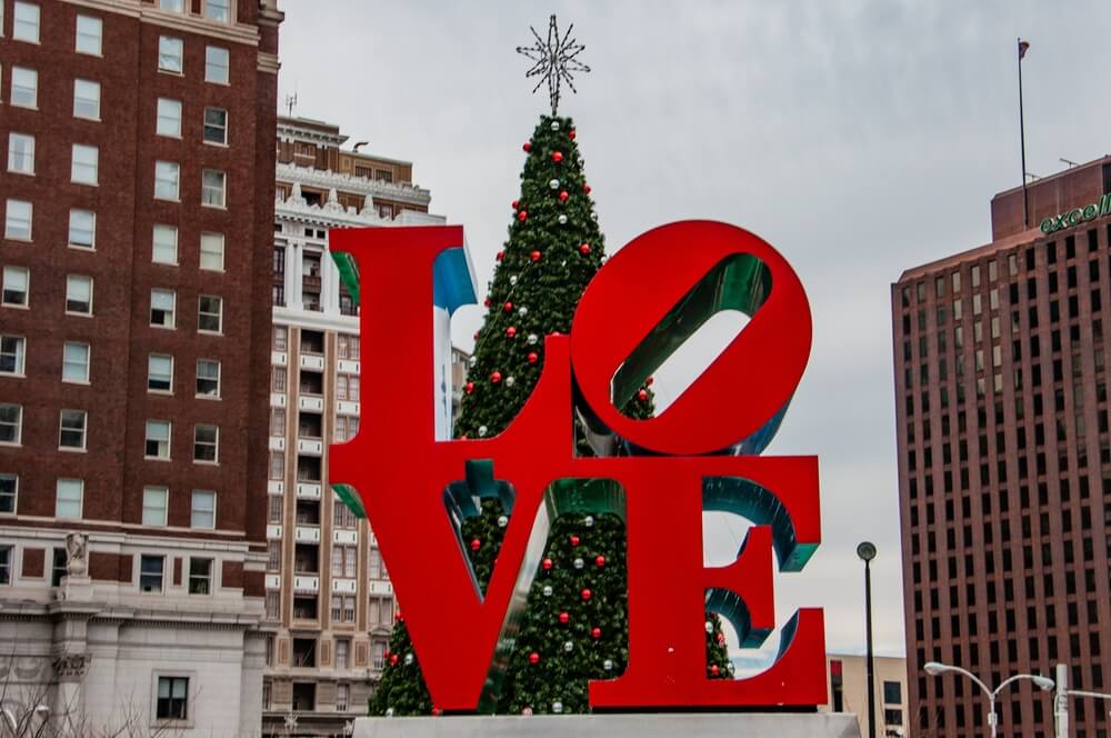 famous philadelphia love sign with a christmas tree behind it