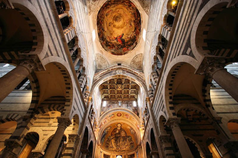 Famous Pisa cathedral with an interior view of the ceiling mosaics and frescoes, with religious iconography.