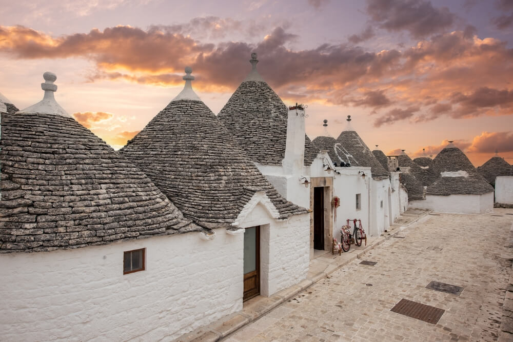 sunset time in the alberobello town of puglia with its famous trulli, some of the alberobello trulli hotels have been converted into boutique hotels