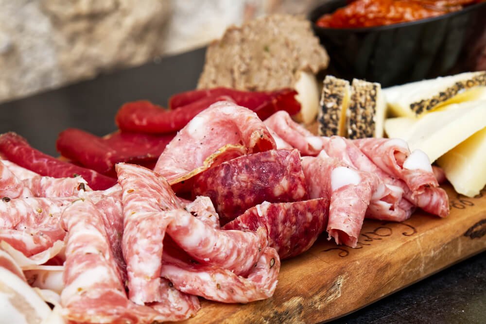 different meats and salamis and cold cuts from italy arranged on a tray during a food tour in siena