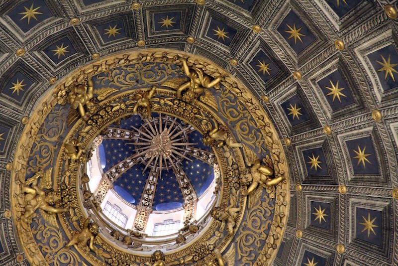 roof view of the siena interior cathedral duomo view with gold gilded detailing and lots of stars and navy backdrop