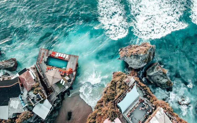 an aerial view of single fin beach club and bar with a pool on the water and a drinks area