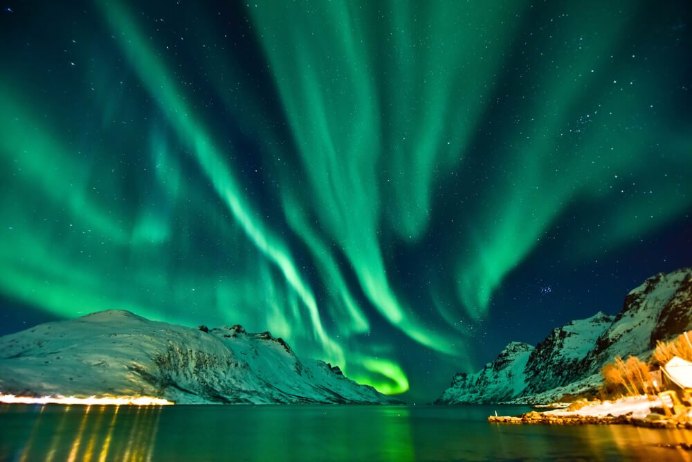 view of the tromso northern lights in the winter with green streaks in the sky