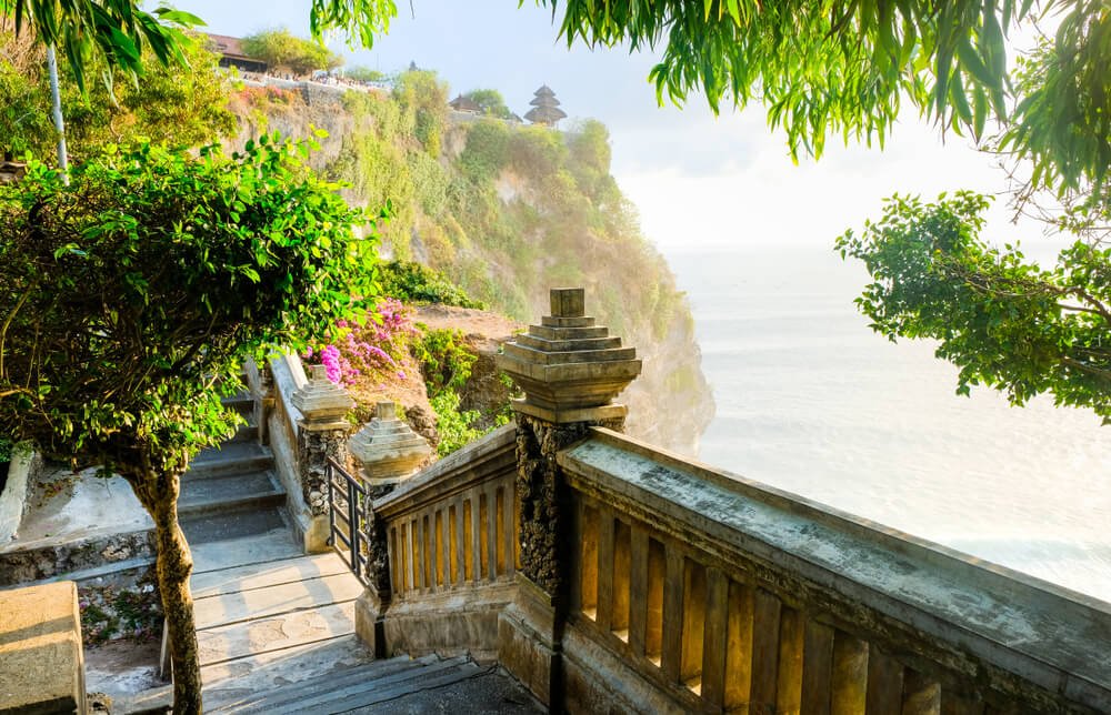 the path leading to the uluwatu temple perched on a cliff with beautiful lighting on the ocean