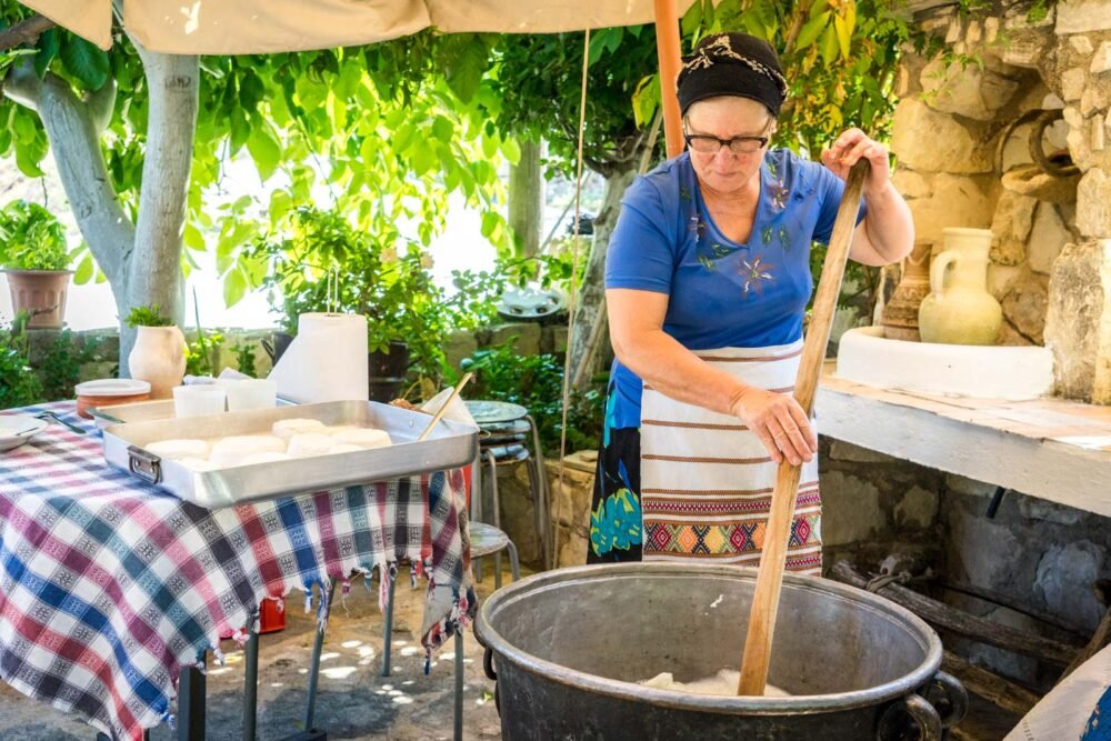 A person making homemade haloumi cheese or another traditional Cypriot food at an outdoor restaurant