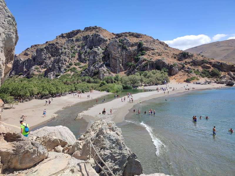 View of people enjoying the water on Preveli Beach in Crete with gorgeous weather on a warm day in the season when you can swim in the water