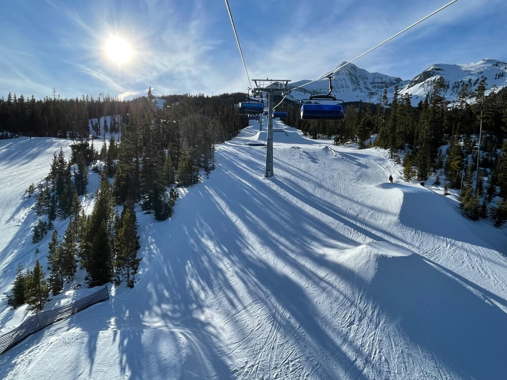 Lovely brilliant sky view of snow covered slopes at Big Sky Ski Resort as seen from the chairlift point of view while skiing on a sunny winter day