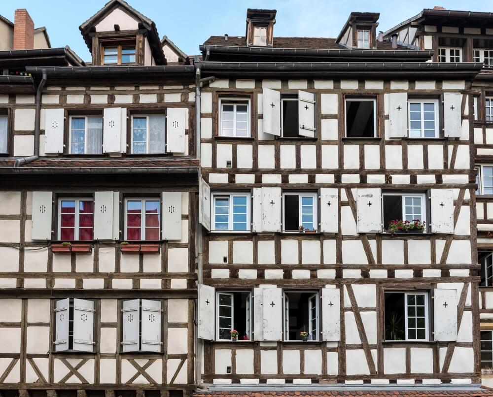 White painted half-timbered houses in the Tanners Quarter area of Colmar, with lots of wood beams and geometrical lines in the old-fashioned architecture