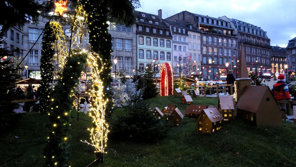 The city of Freiburg in Germany with all its Christmas market decorations around dusk when the lights are just starting to twinkle on.