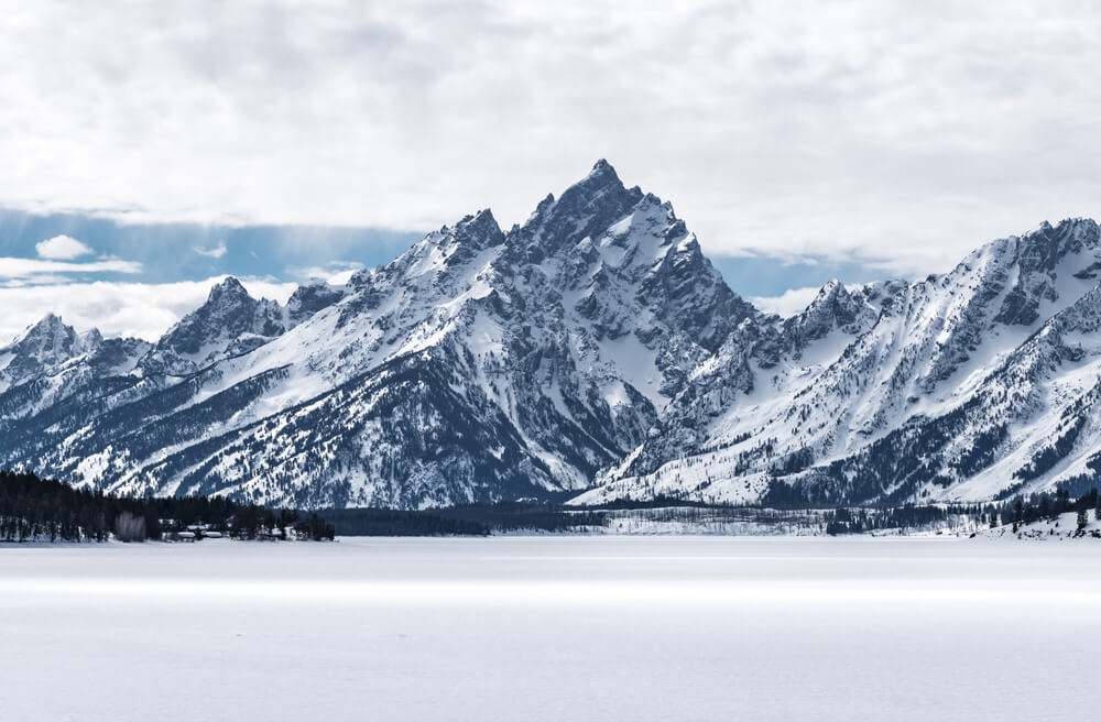 Snowmobile tour through the landscapes of Grand Teton national park with pristine field of white snow