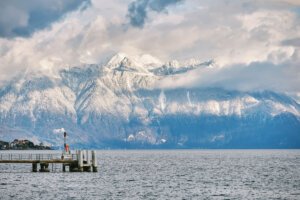 Montreux boats on the water of Lake Geneva with snow and pier and clouds in the winter