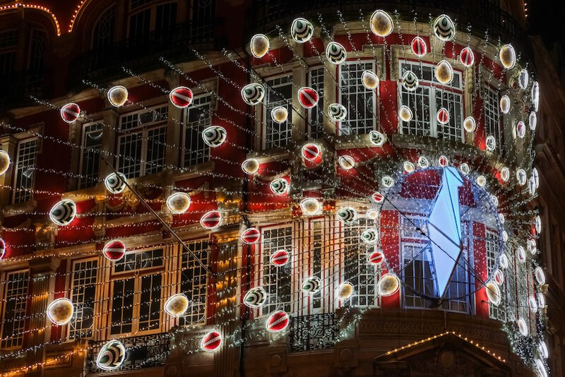 Red building face with Christmas lights in Porto in the winter with all the Christmas decroations in red and green and and gold