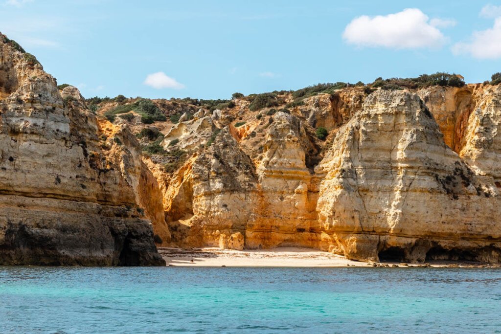 One of the beautiful beaches in the Lagos area as seen from the water so you can admire the tall sea cliffs in this part of coastal Portugal in the Algarve region in winter