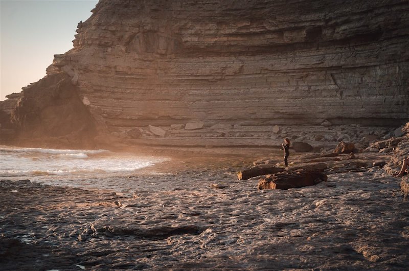 a view of ericeira beach at sunset with golden light on the shores