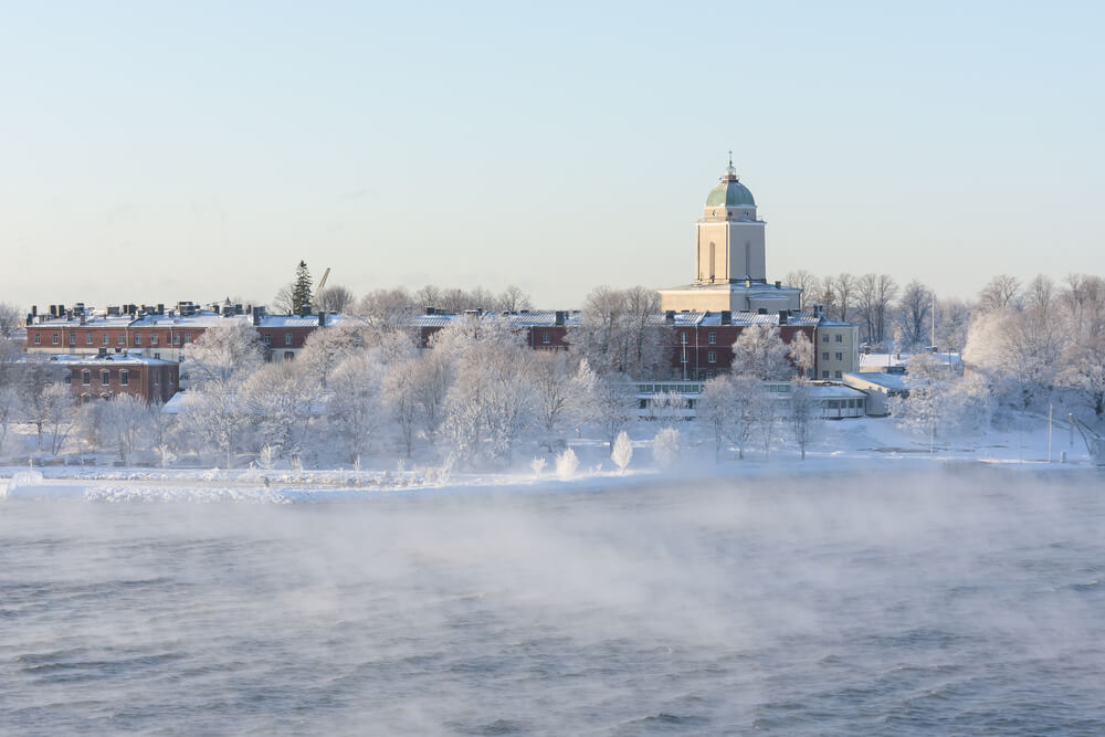 View of some of the key buildings and structures on Suomenlinna in the winter with misty waters and snowy island