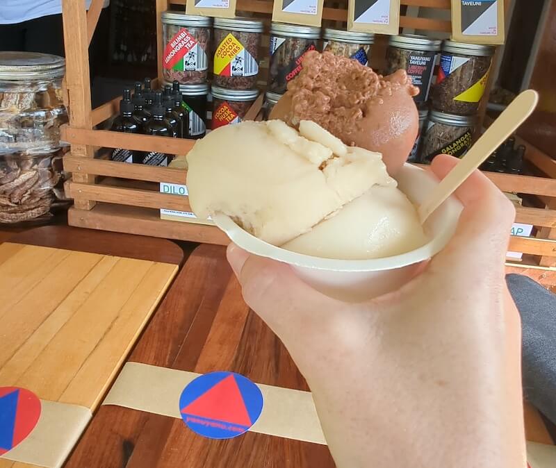 Three scoops of ice cream from a road side stall including chocolate and fruit sorbet flavors