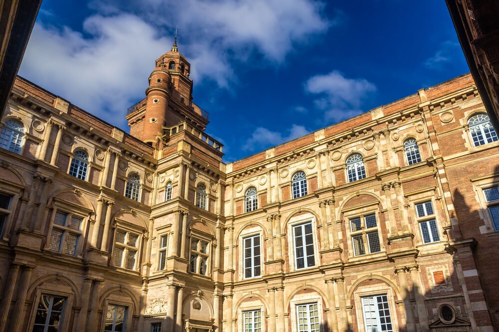 Winter scene of a hotel in toulouse france with beautiful pinkish orange brickwork in the architecture