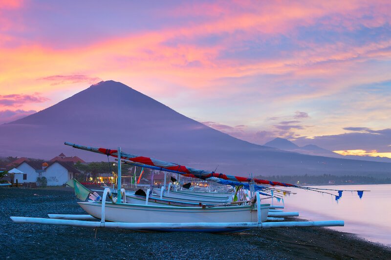 Streaky clouds in the sky and traditional fishing boats in Amed, Bali, Indonesia with Mount Agung in the background looking beautiful