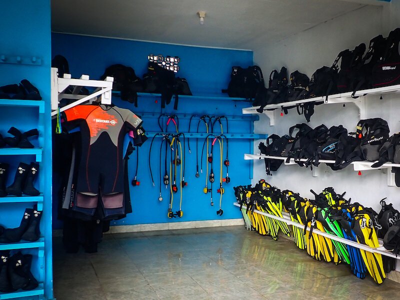Regulators, fins, BCDs, and other scuba gear at a dive shop in Amed