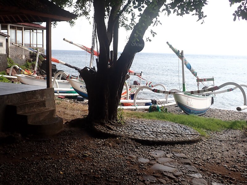 Traditional wooden Balinese boats outside the Japanese shipwreck dive site on a clear day in Amed