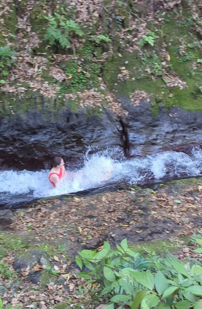 Allison in a red bathing suit going down the water slide in Taveuni