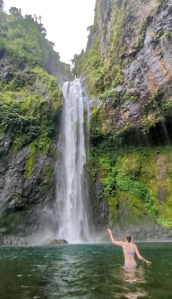 Allison Green putting her hand up so you can see the true size of Savulelele Waterfall