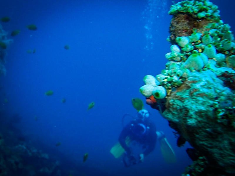 Another diver visible in the distance so you can see the scale of the shipwreck