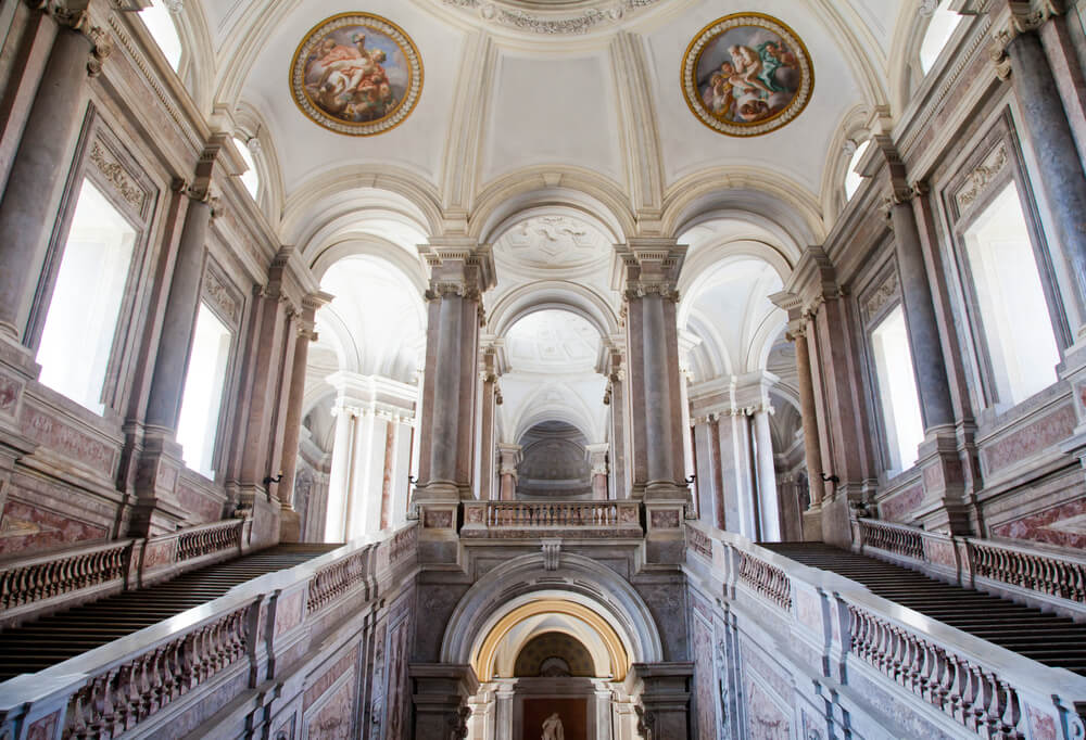 Interior of the Reggio caserta with orange marble work and fresco painted ceilings with a mostly white minimalist interior