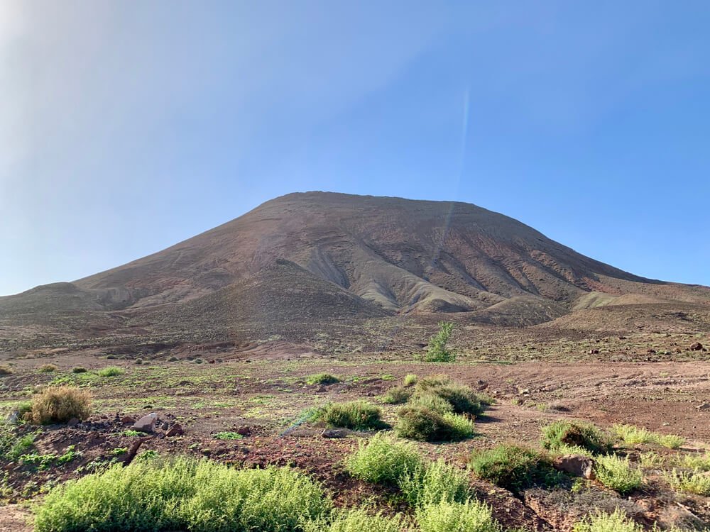 bayuyo volcano in Fuerteventura on a clear day with the hiking trail ahead of you and the mountain