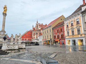 the charming glavni square in Maribor with pink and beige buildings round the central square