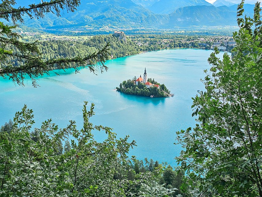view of the small island with a church on it on the center of lake bled, a beautiful turquoise lake in Slovenia