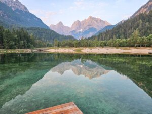peaceful calm waters of lake janna reflecting mountains above it in the water, and view of a dock in the foreground