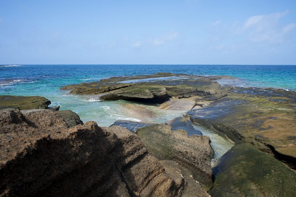 beautiful natural beach of playa de los dojos in fuerteventura in the national park with jagged landscape and rocks leading into the water