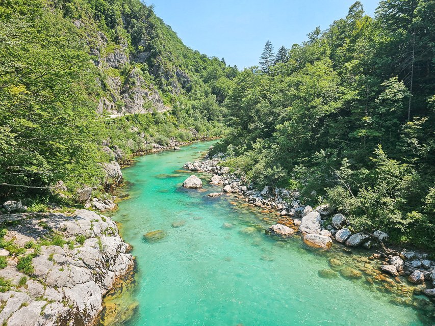 bright turquoise river called the soca river in the heart of Slovenia with gorgeous foliage on the sides of the river water