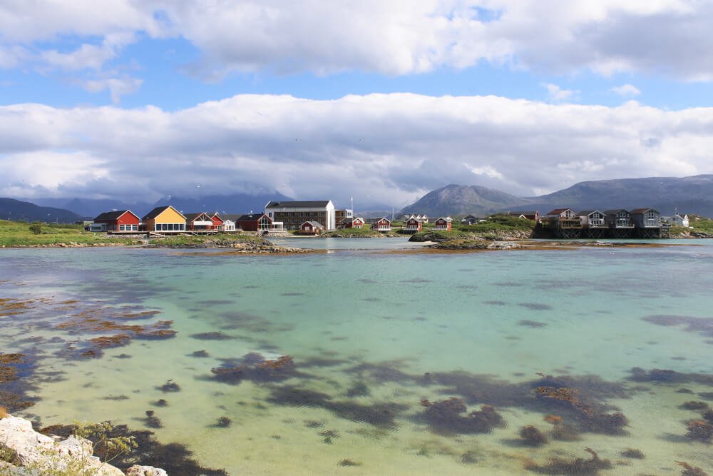 Beautiful clear waters in Sommaroy near Tromso with the fishing village behind you