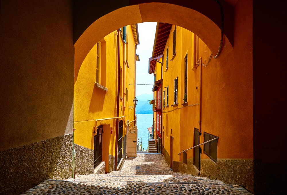 an archway in the central town of varenna with view down to the lake from a viewpoint up on a hill