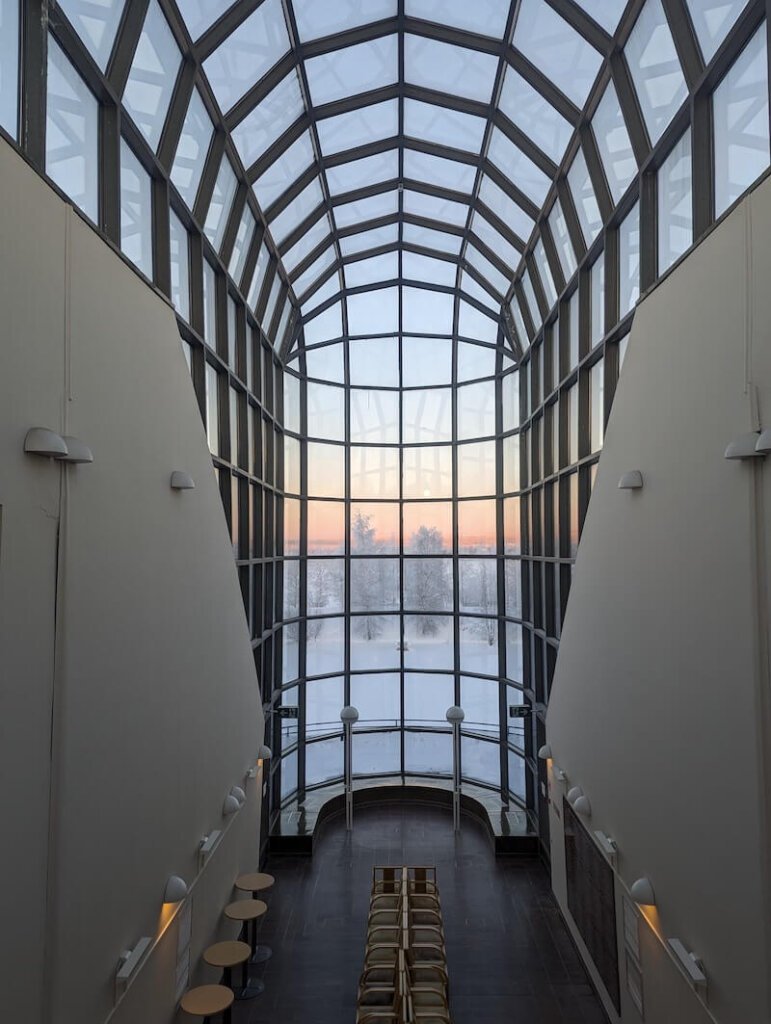 View of the arctic landscape in the background with the raised glass roof and dome of the arktikum museum