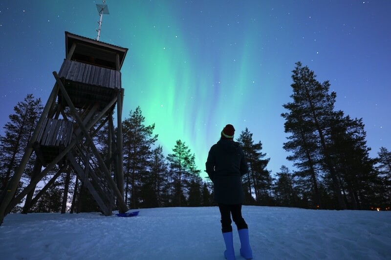 Allison looking at the aurora swirling overhead on a beautiful arctic night in March
