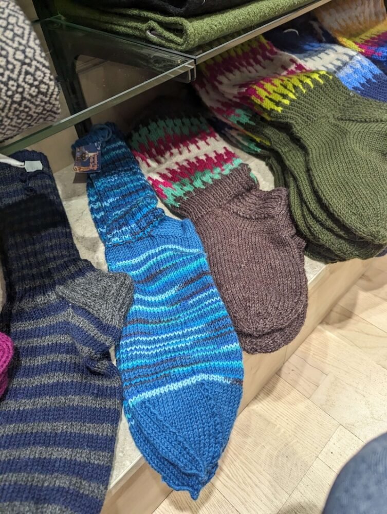 Wool socks in Lapland in a variety of colors: black with stripes, blue, brown, and olive green.