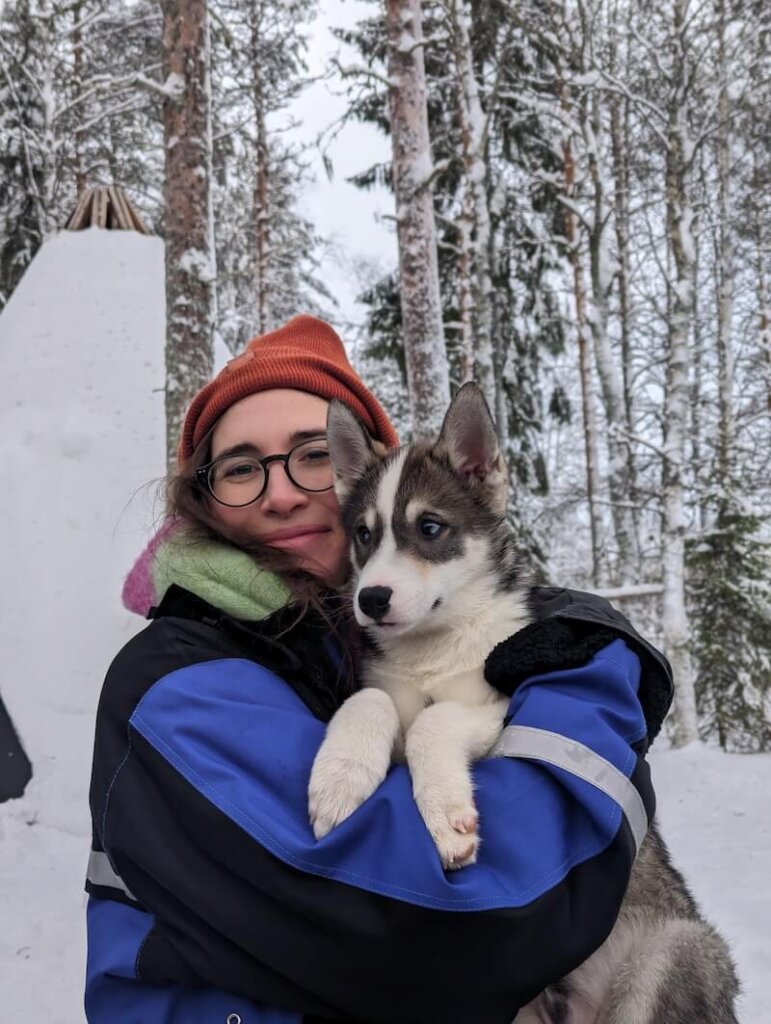 Holding a husky puppy at Apukka Resort after finishing a dog sled excursion