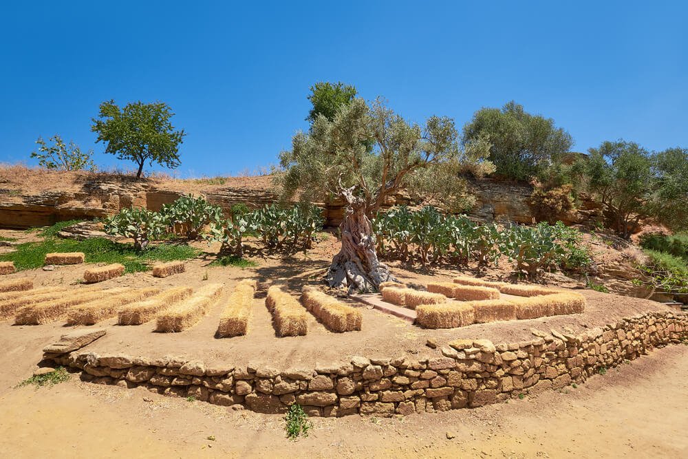 Agrigento's Kolymbethra Garden with hay bales, small wall, and desert-like arid landscape of sicily in summer
