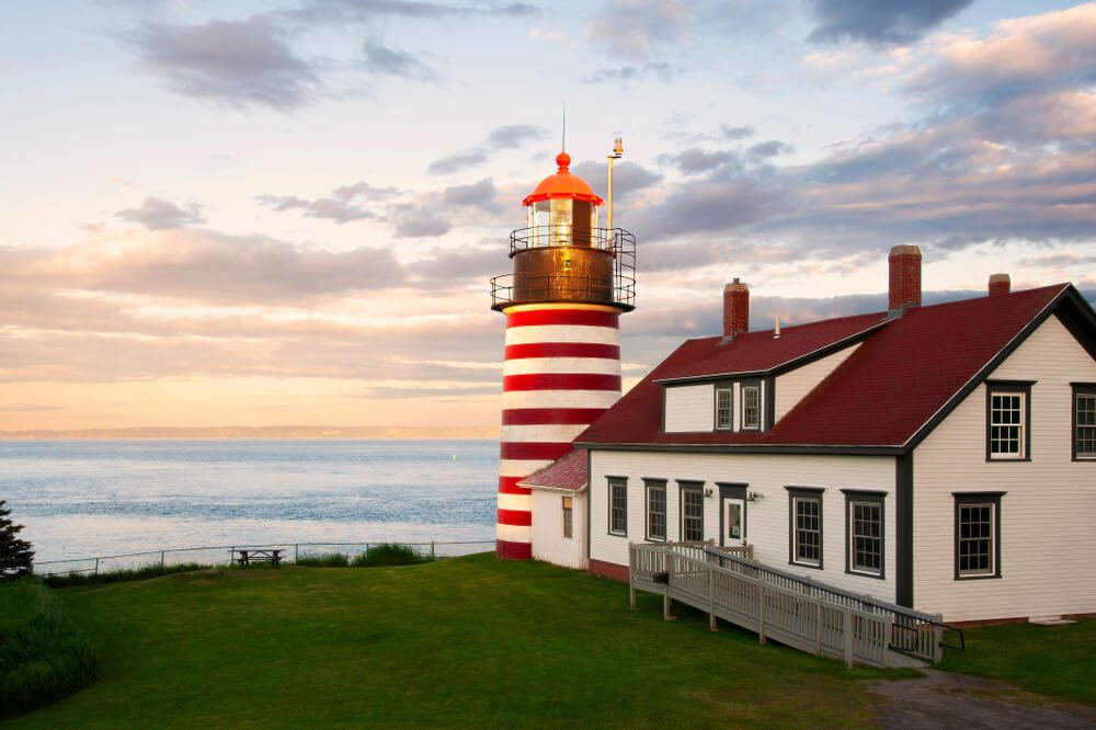 lighthouse with striped candy cane line stripes at sunset on the maine coast