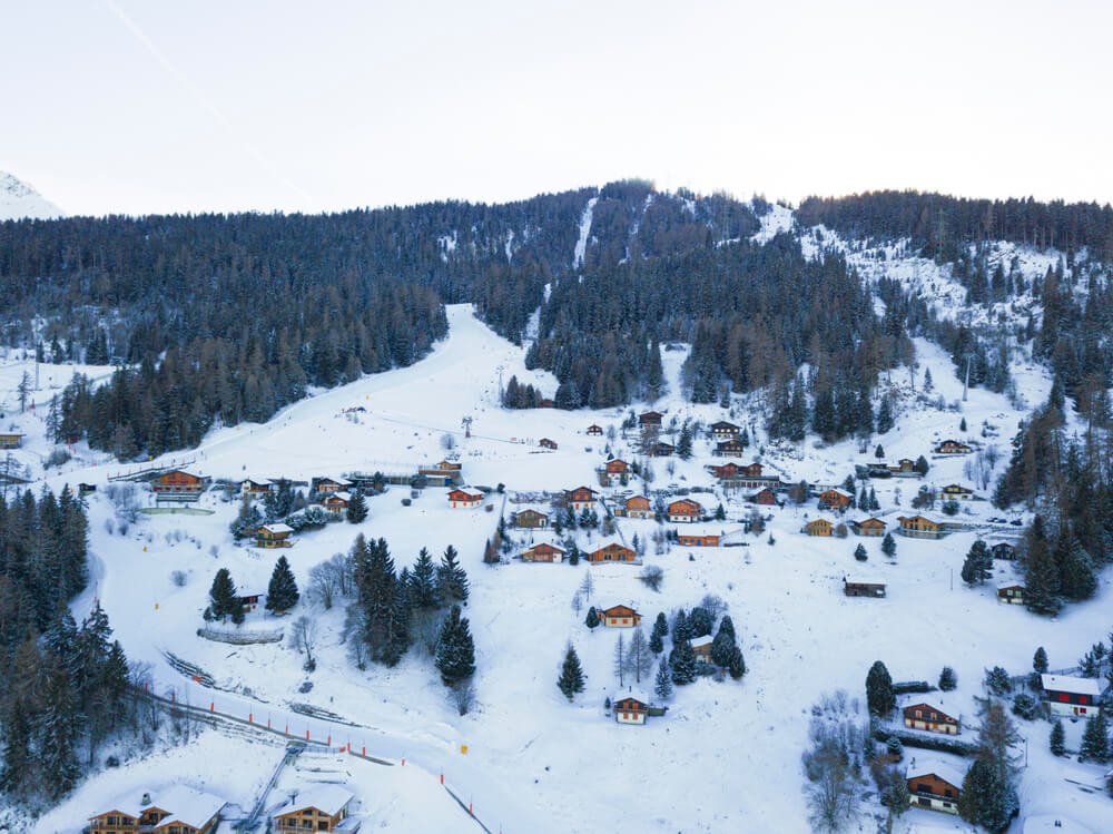 View of the ski town of La Tzoumaz as seen from above in the winter with lots of snow on the chalets and buildings