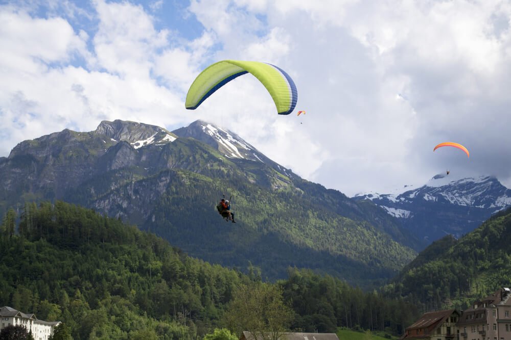 Several paragliders in the air, including tandem paragliders