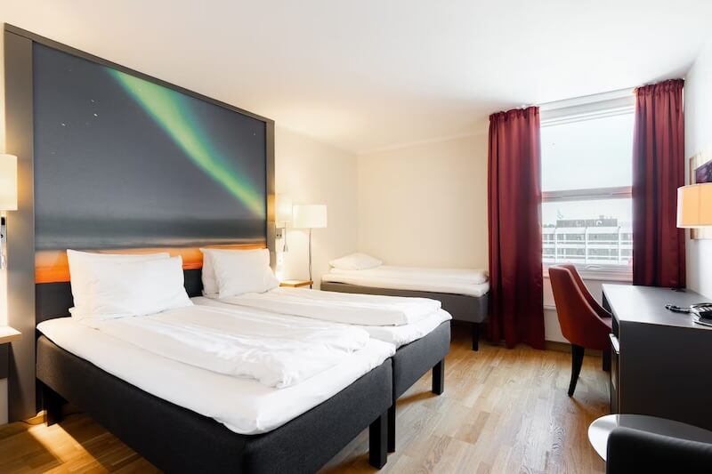 Interior of the scandic hotel with a white bed and aurora painting