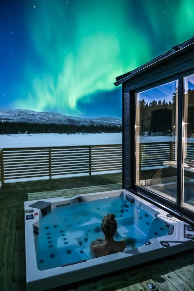 Aurora over the cabin and jacuzzi in the winter