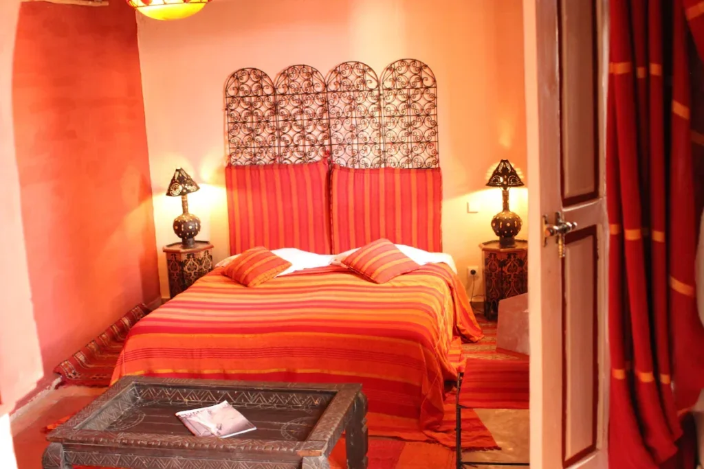 Orange and red colors inside a riad bedroom in Marrakech with traditional style decor