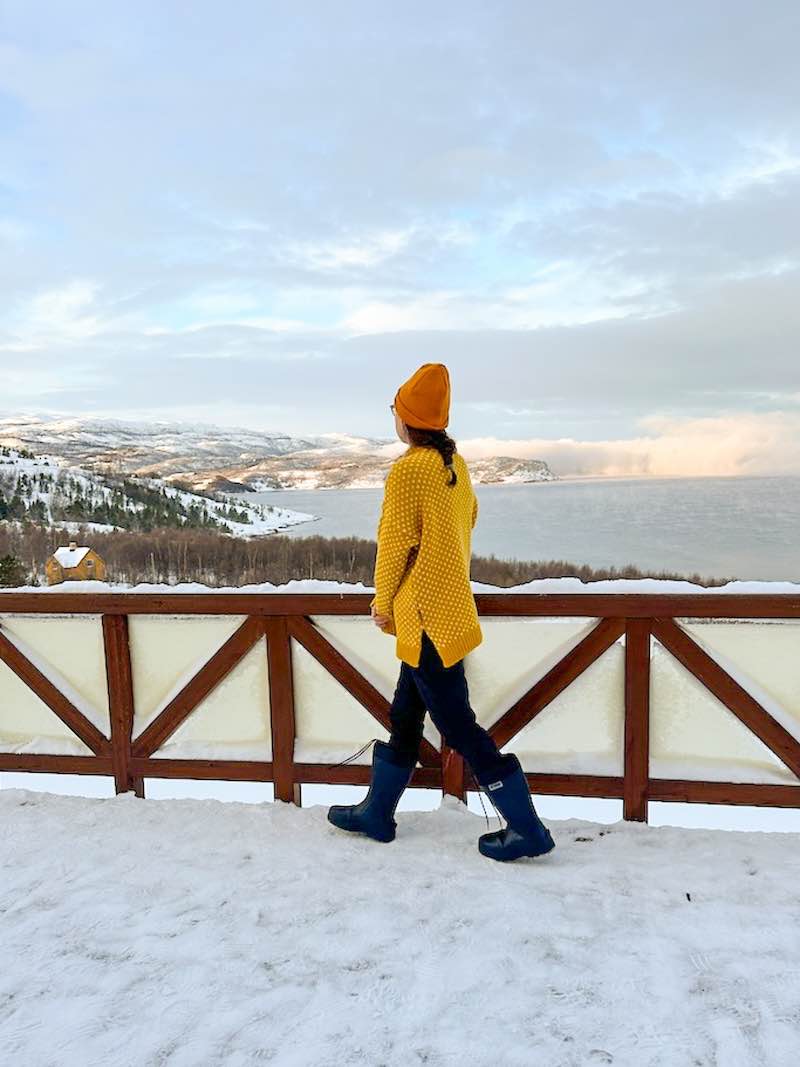 Allison walking along the balcony at the alta museum overlooking the fjord